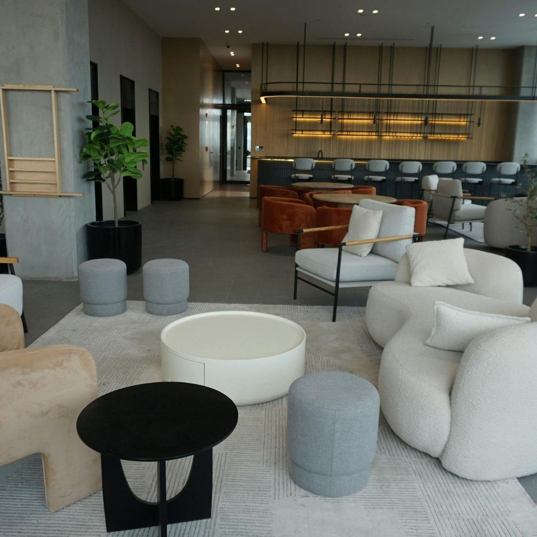 “Modern koltuk, sehpa, aydınlatma ve dekoratif aksesuarlarla tasarlanmış şık ve konforlu oturma odası dekorasyon görseli”